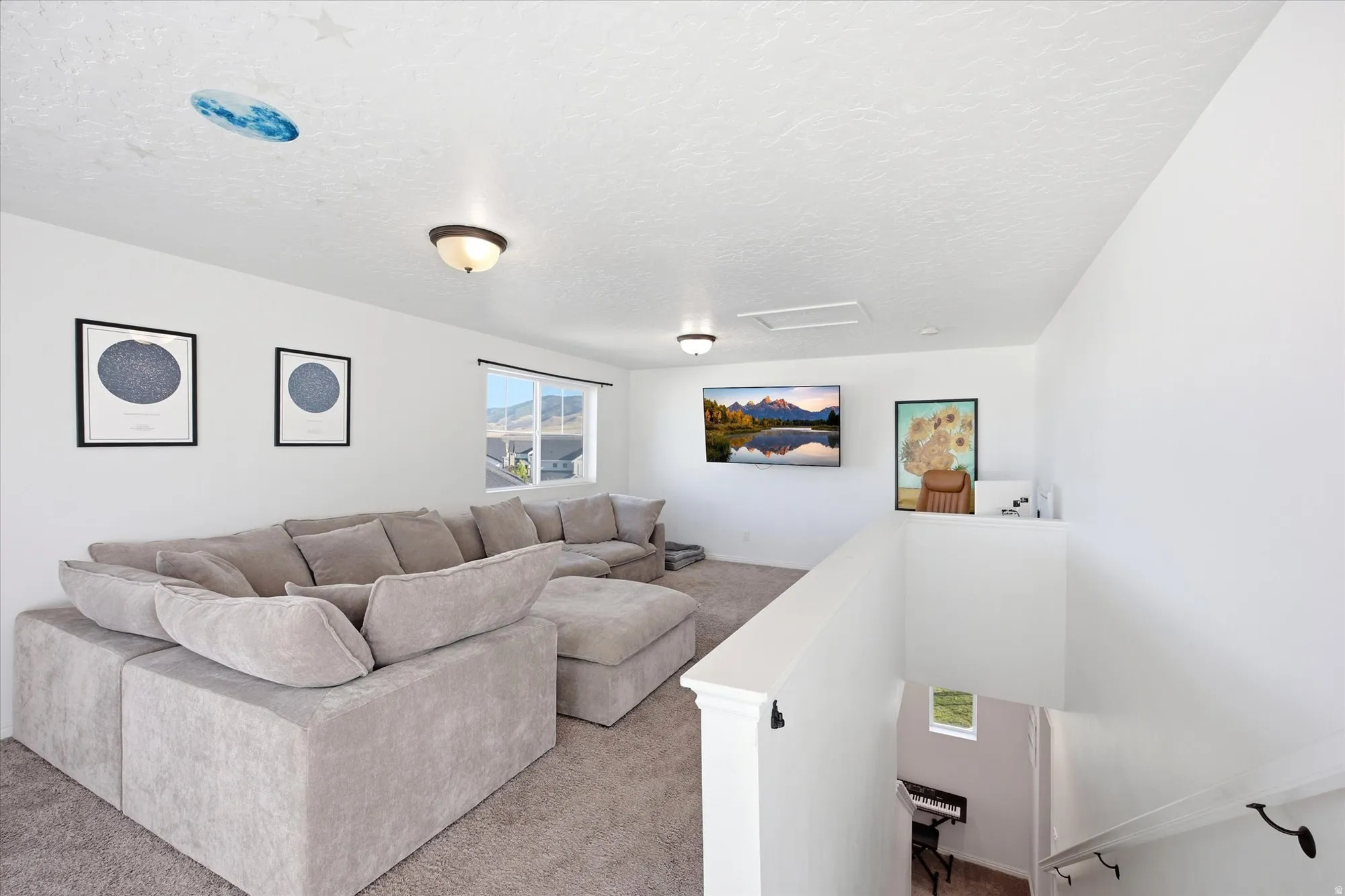 Spacious carpeted bonus room featuring a window overlooking mountains, recessed lighting, and a built-in media wall