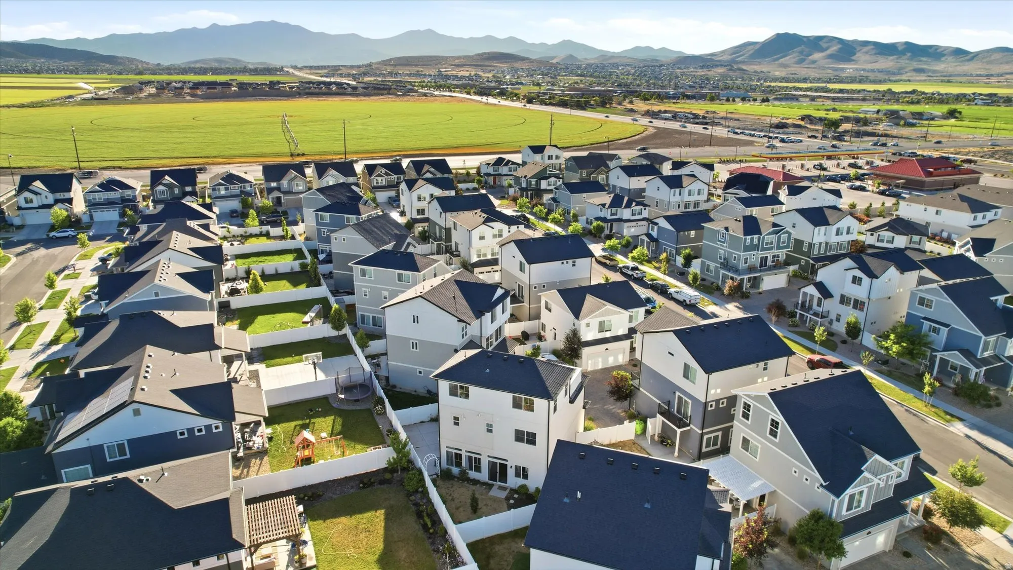 Aerial overview of a residential community featuring varied architectural styles and dark-pitched roofs