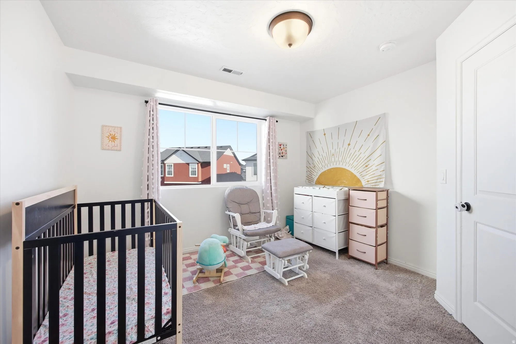 Room featuring a window, textured carpet flooring, white walls, and a ceiling-mounted light fixture
