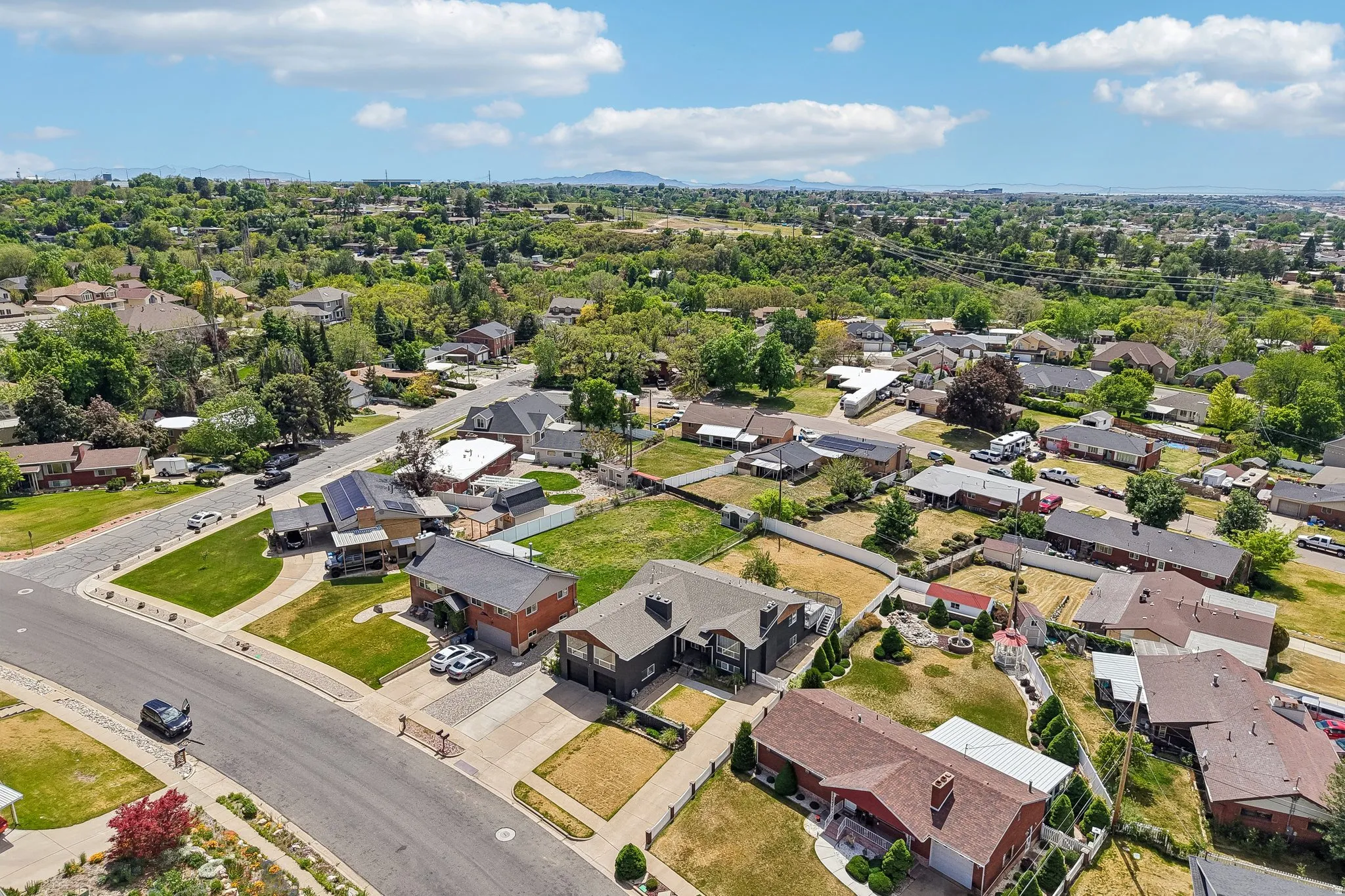 Residential neighborhood featuring diverse home styles, paved streets, and mature landscaping