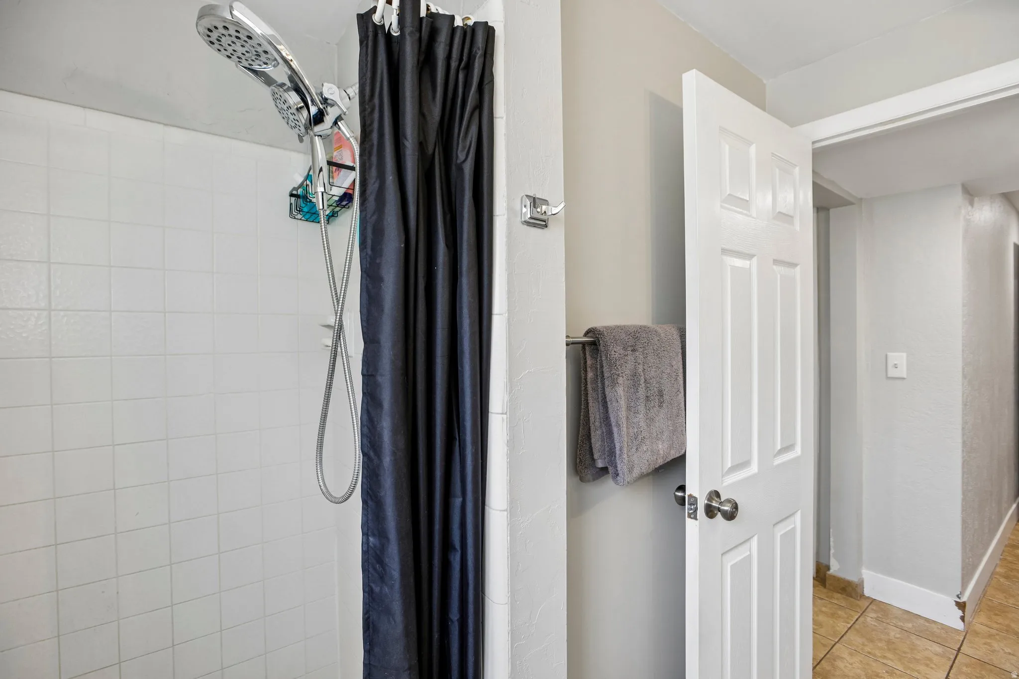 Shower with white tiled walls and a multi-function showerhead