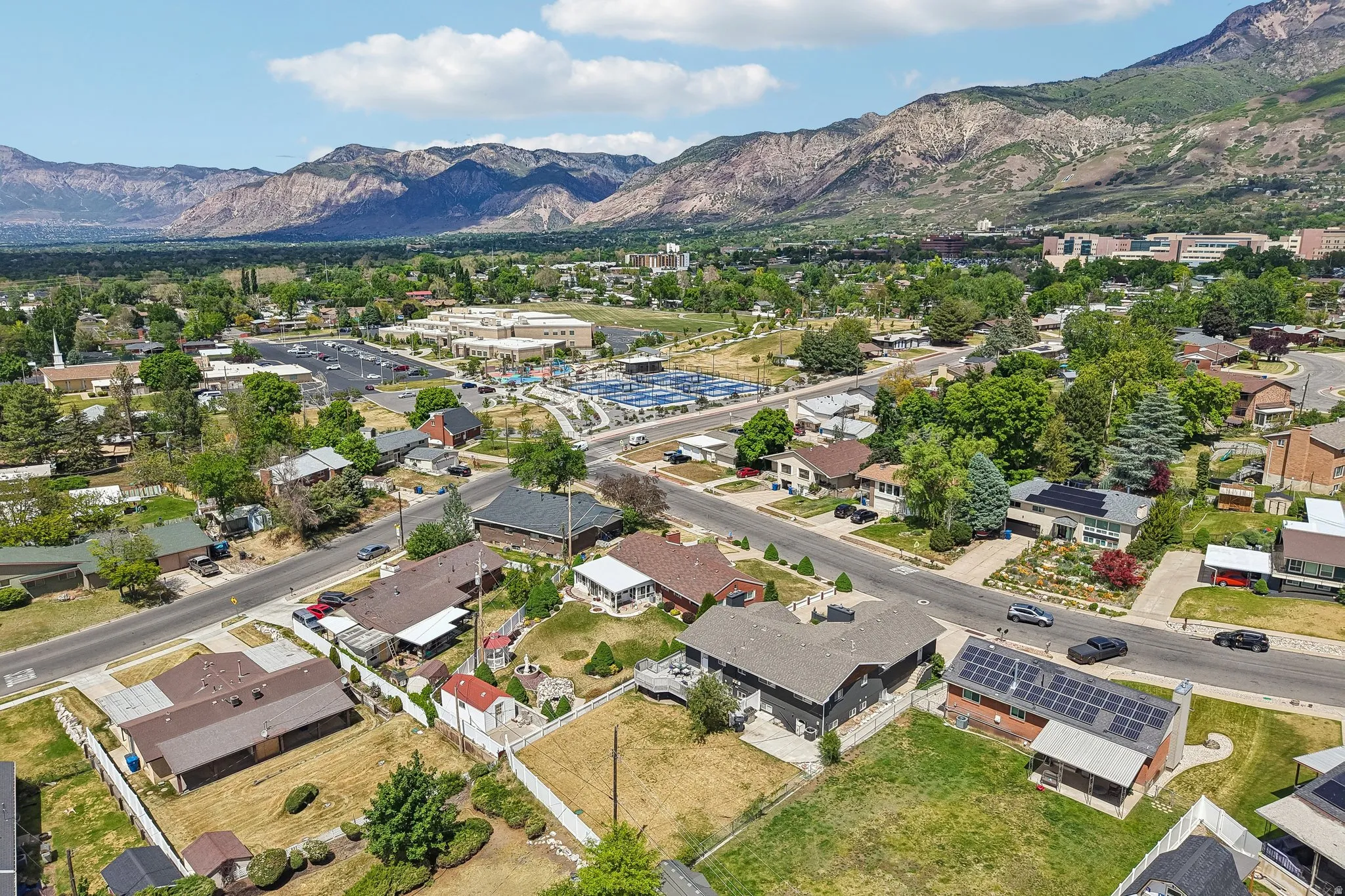Expansive neighborhood setting featuring mature trees and mountain backdrops