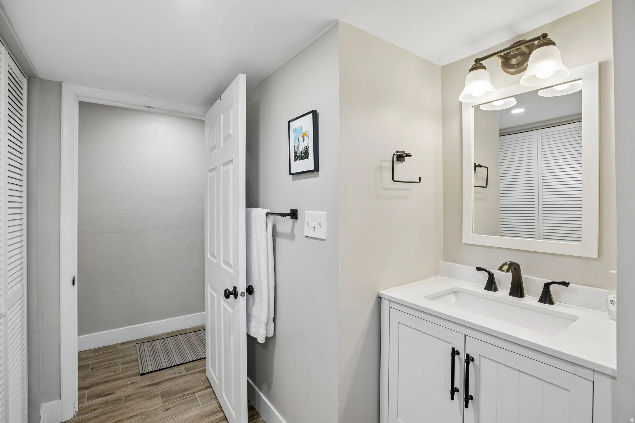 Bathroom featuring a white vanity with a rectangular sink, a white countertop, and matte black fixtures