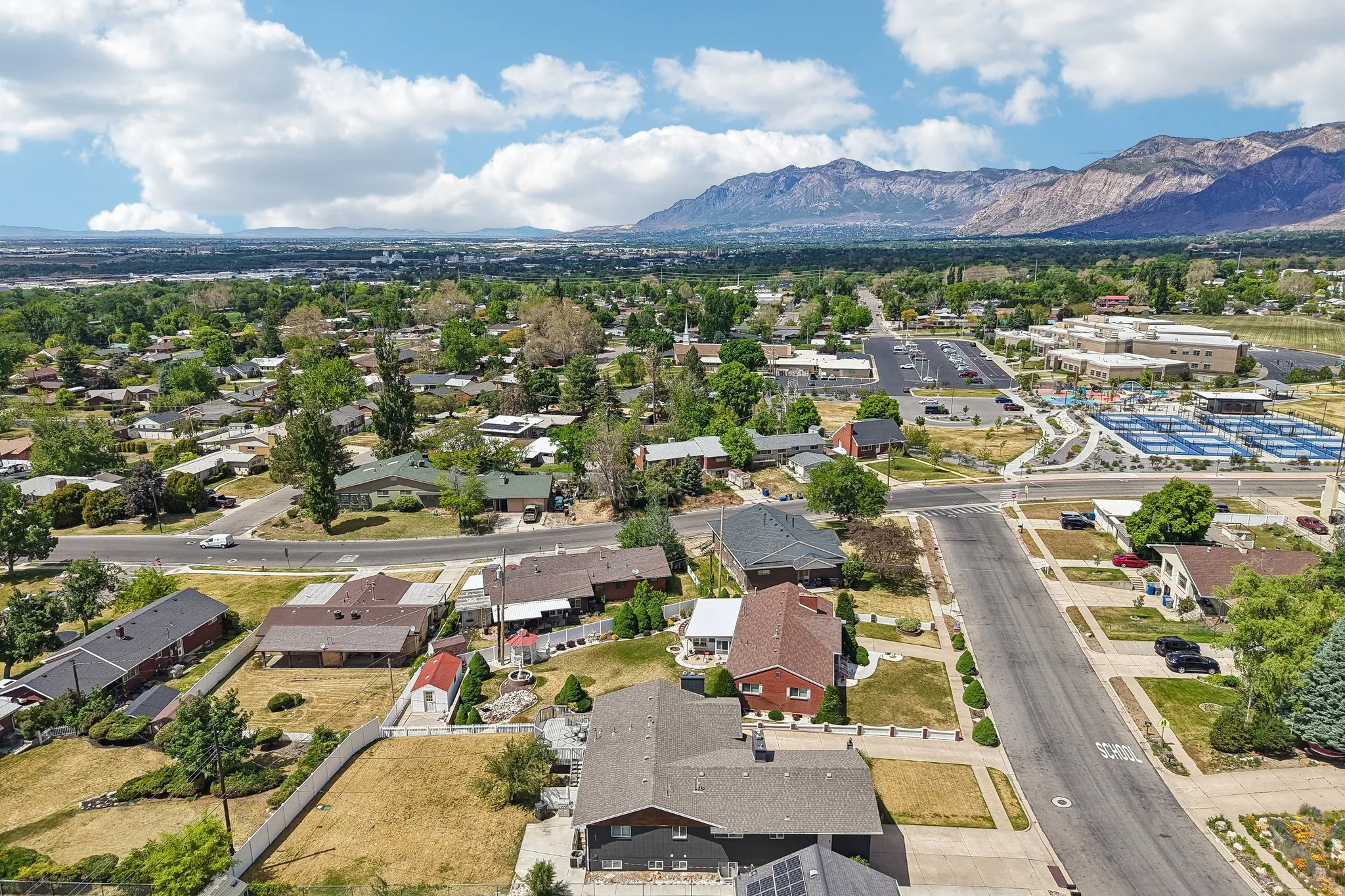 Expansive neighborhood aerial with mountain backdrop