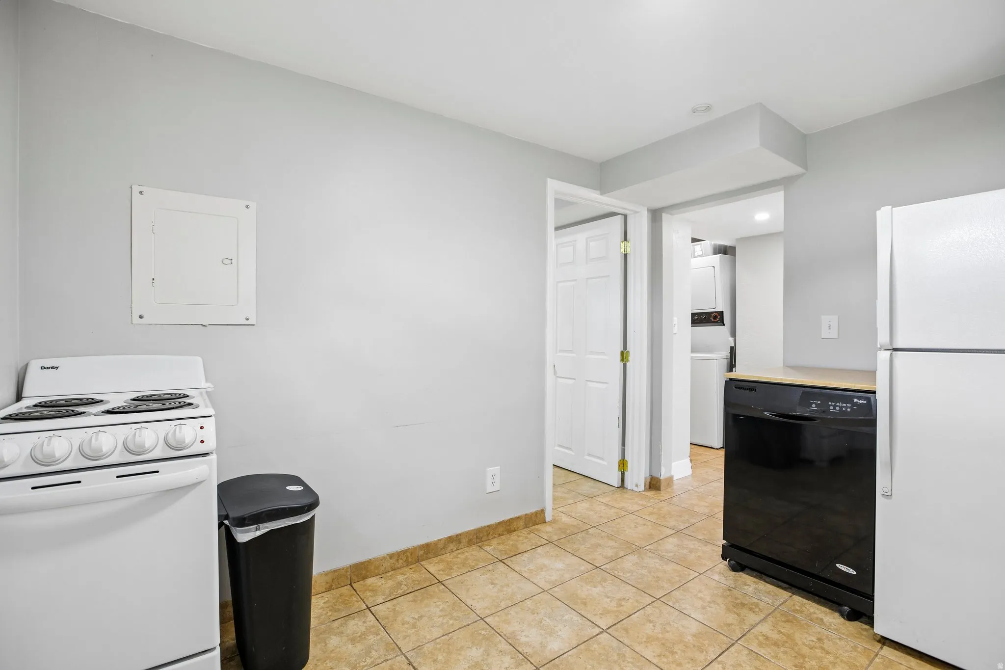 Kitchen area featuring light gray walls, tile flooring, a white electric range, and a white refrigerator