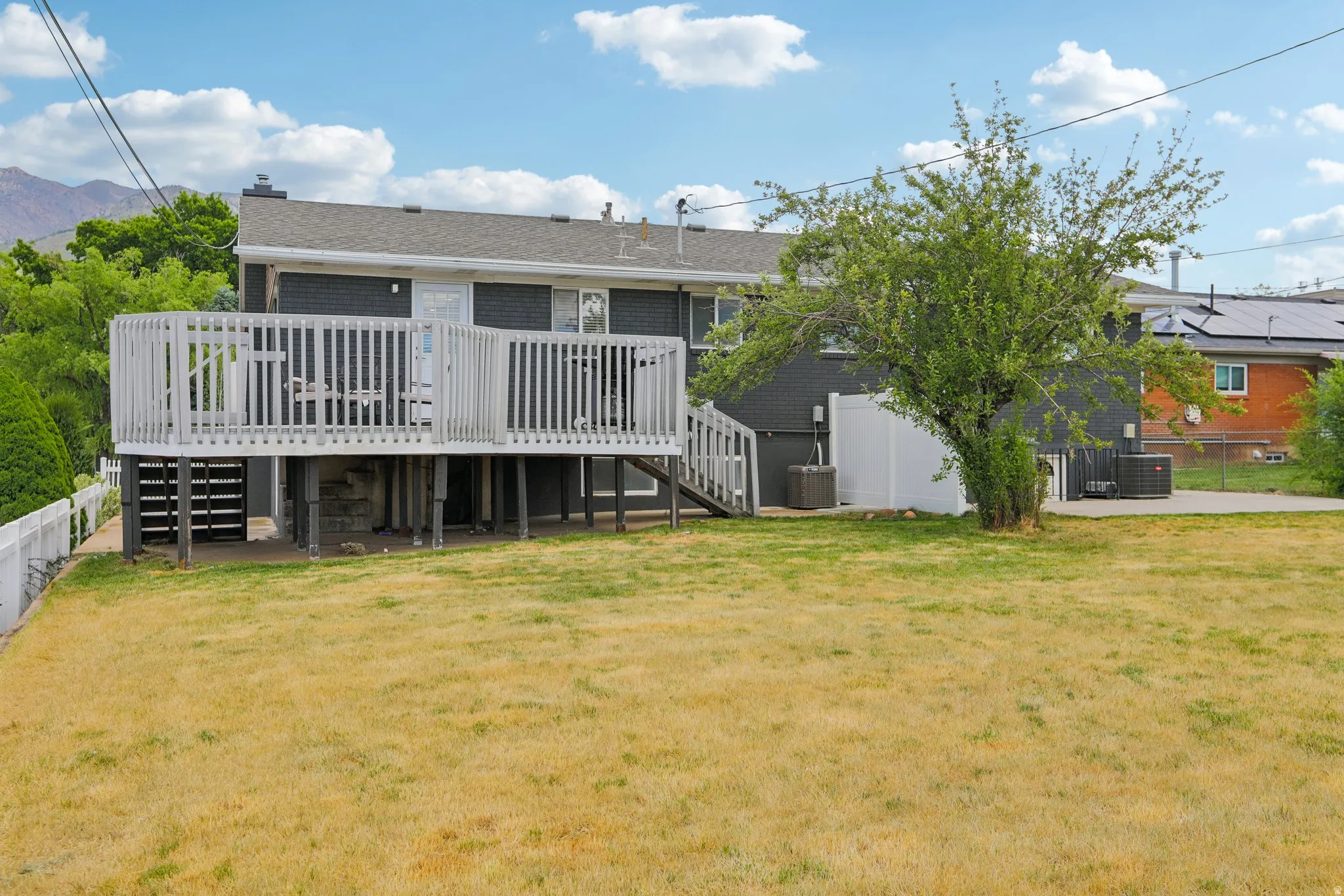 Elevated rear deck with white railing, exterior staircase, and direct access to the interior