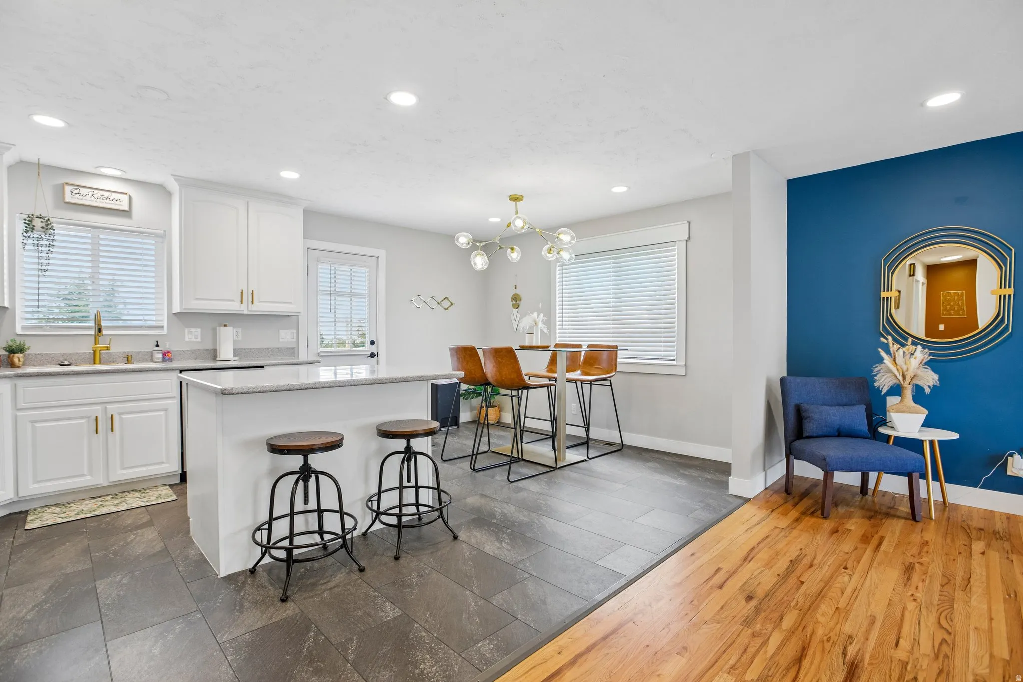 Modern kitchen featuring white cabinetry, light-toned countertops, and a white island with seating