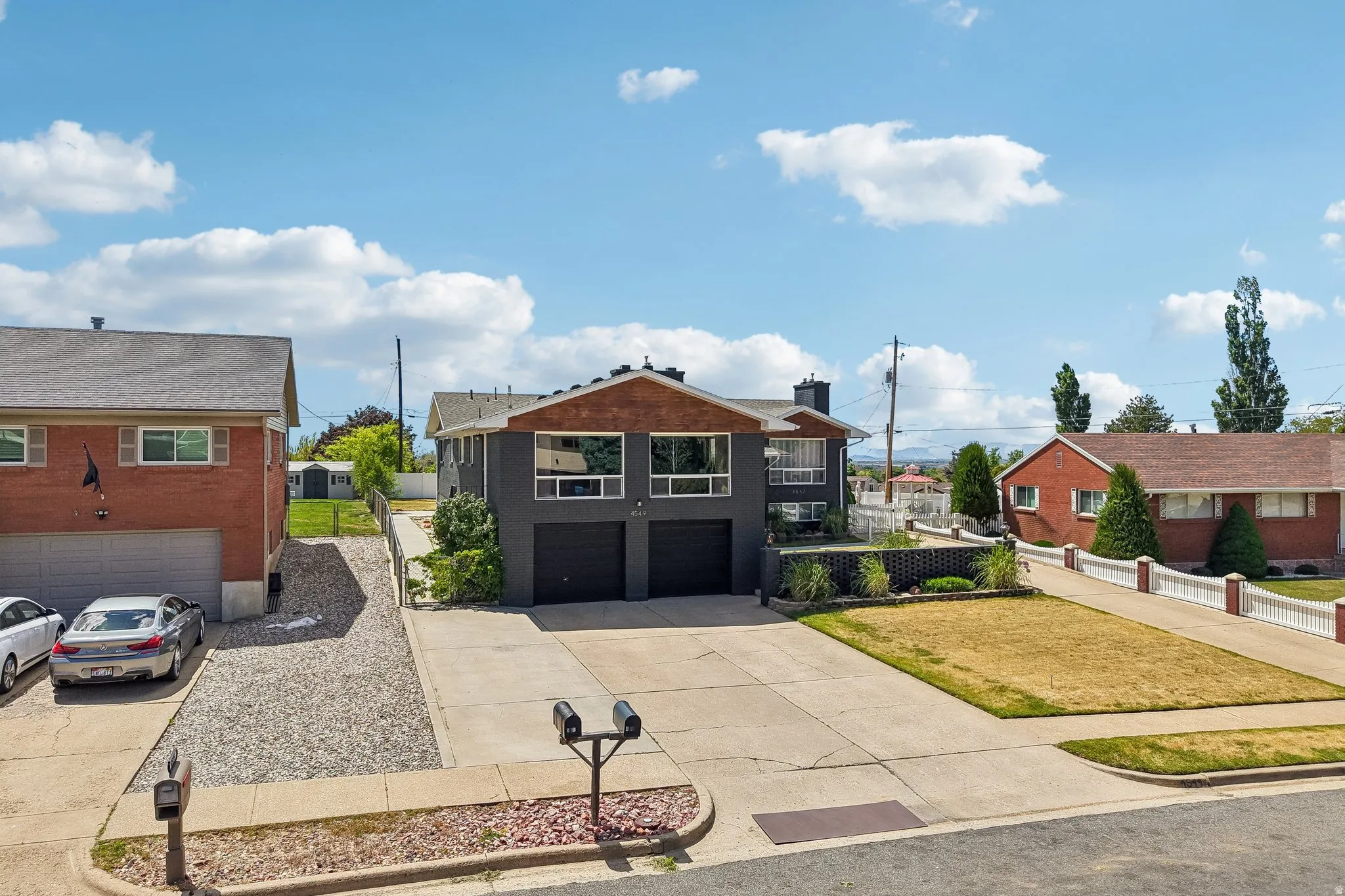 Contemporary split-level residence featuring a two-car garage and a paved driveway