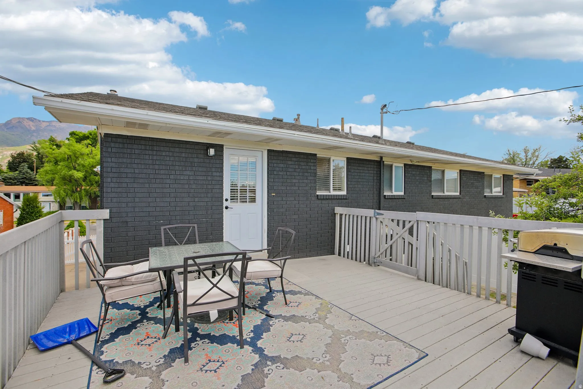 Expansive outdoor deck featuring wood-finish flooring and a light-toned railing system