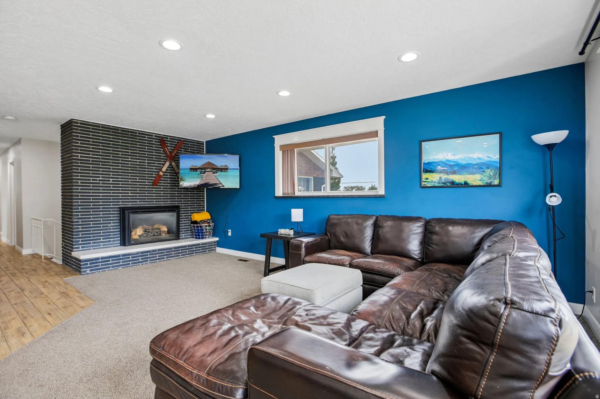 Spacious living area featuring a modern fireplace with a dark brick surround and a light-toned hearth