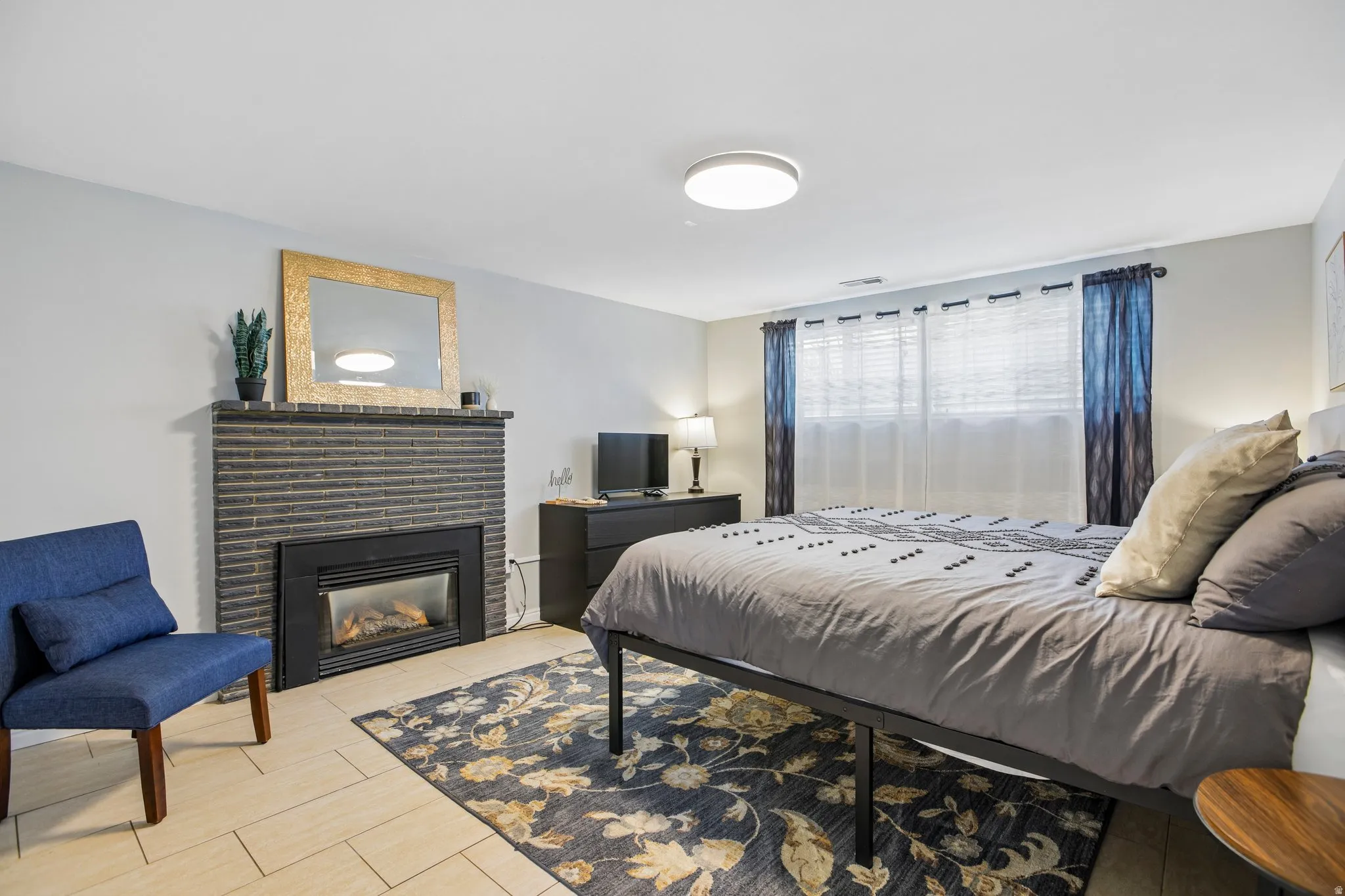 Built-in fireplace with a dark brick surround and mantel, complemented by light-toned tile flooring