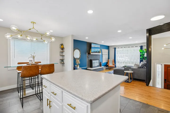 Kitchen island with a light-colored countertop and white cabinetry featuring gold-finish hardware