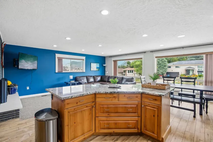 Kitchen island with a granite-style countertop and wood cabinetry