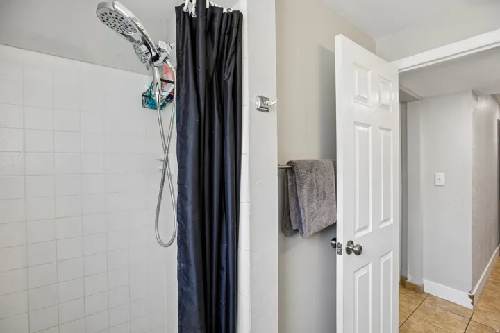 Shower with white tiled walls and a multi-function showerhead
