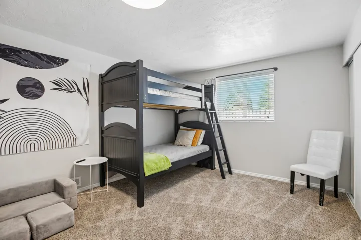Neutral gray painted walls, light brown textured carpeting, and a window with blinds