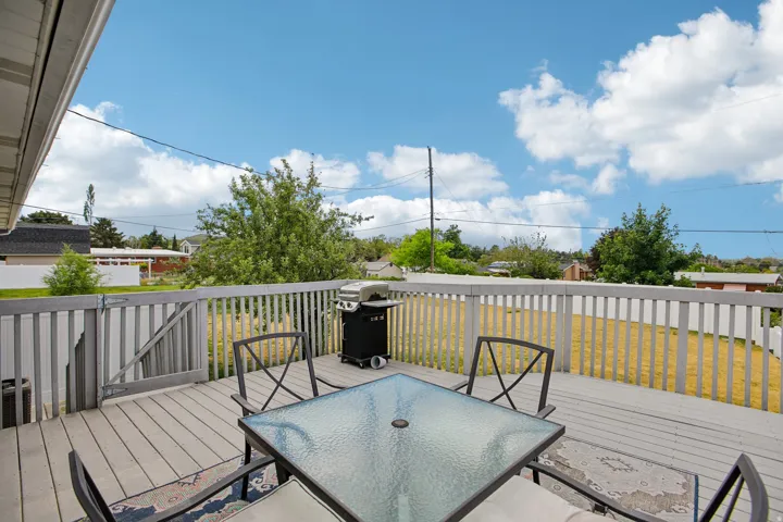 Expansive outdoor wood-finish deck featuring a full railing system and a gate