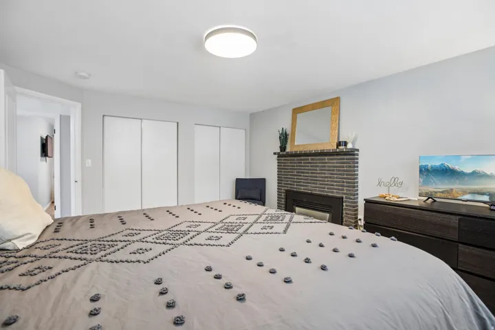 Bedroom featuring a built-in fireplace with a brick surround, a mantel, and an inset firebox