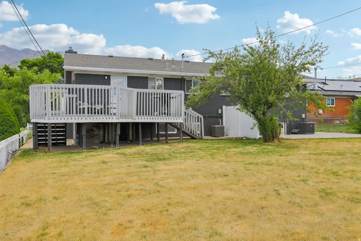 Elevated rear deck with white railing, exterior staircase, and direct access to the interior