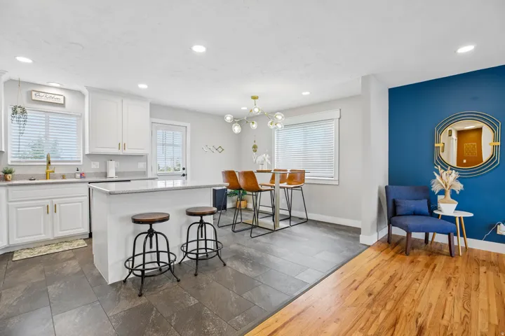 Modern kitchen featuring white cabinetry, light-toned countertops, and a white island with seating