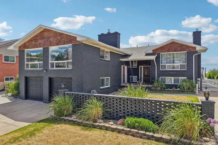 Charcoal brick exterior featuring wood-finish gables and a two-car garage