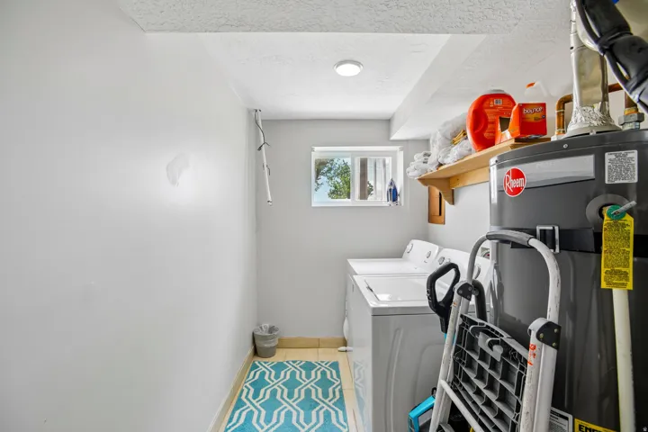 Dedicated laundry area featuring a window, overhead shelving, and recessed lighting