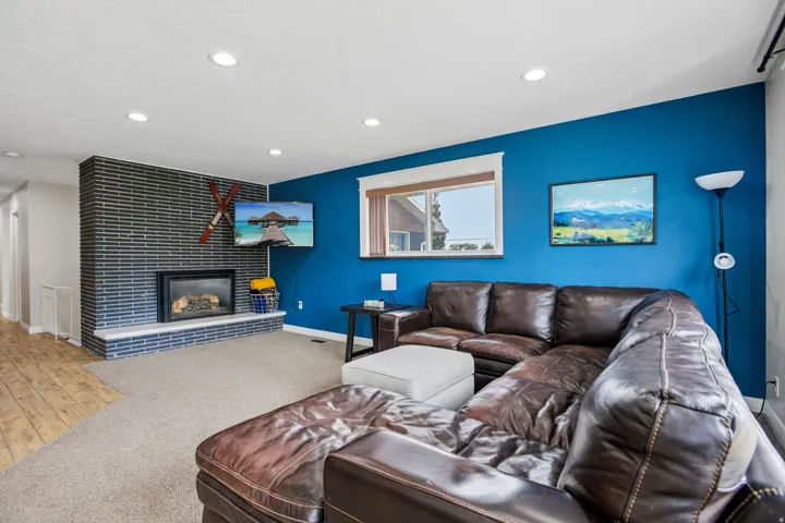 Spacious living area featuring a modern fireplace with a dark brick surround and a light-toned hearth