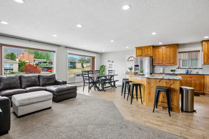 Open-concept living space featuring wood-finish flooring, recessed lighting, and large picture windows