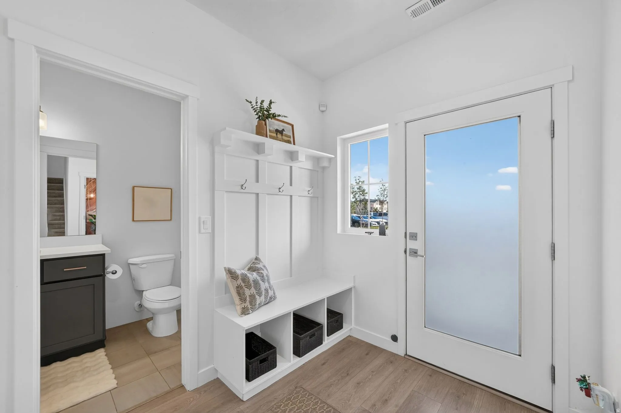 Entryway featuring a built-in coat rack and bench with cubby storage