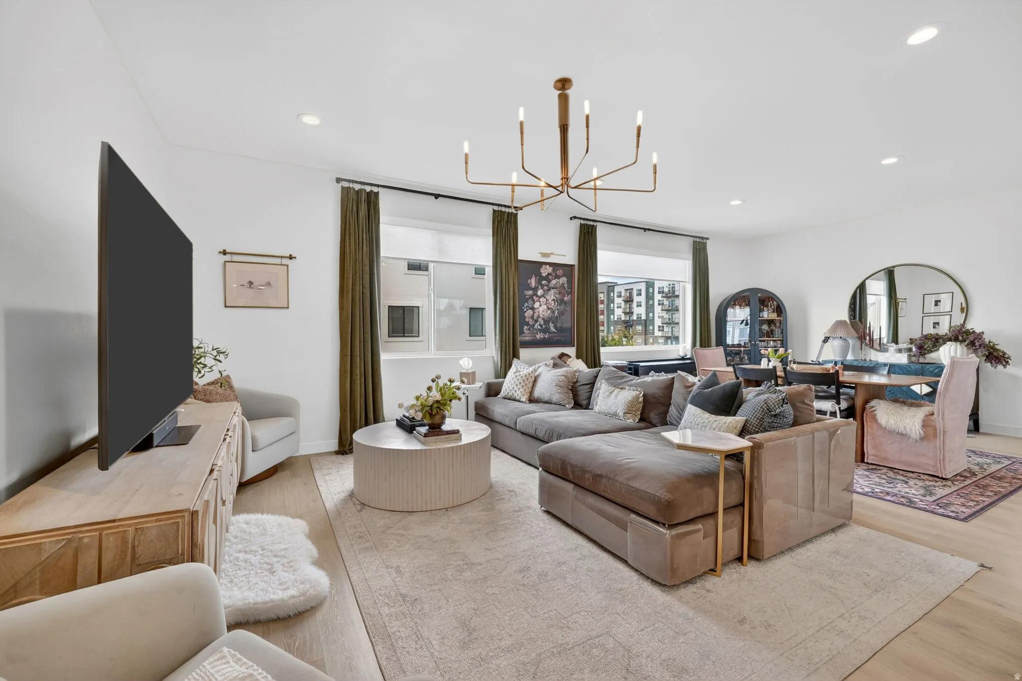 Bright open-concept living space with recessed lighting and a contemporary chandelier