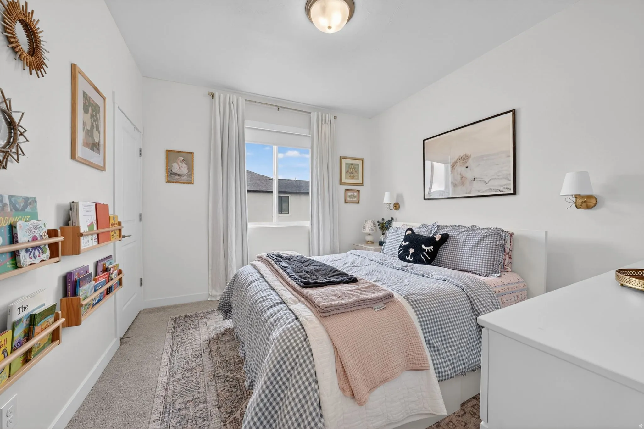 Bright room featuring a single window with white drapery, white walls, and neutral carpet flooring
