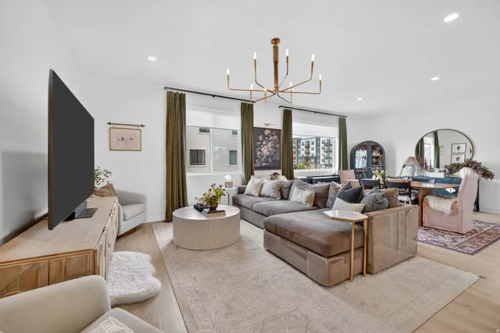 Bright open-concept living space with recessed lighting and a contemporary chandelier