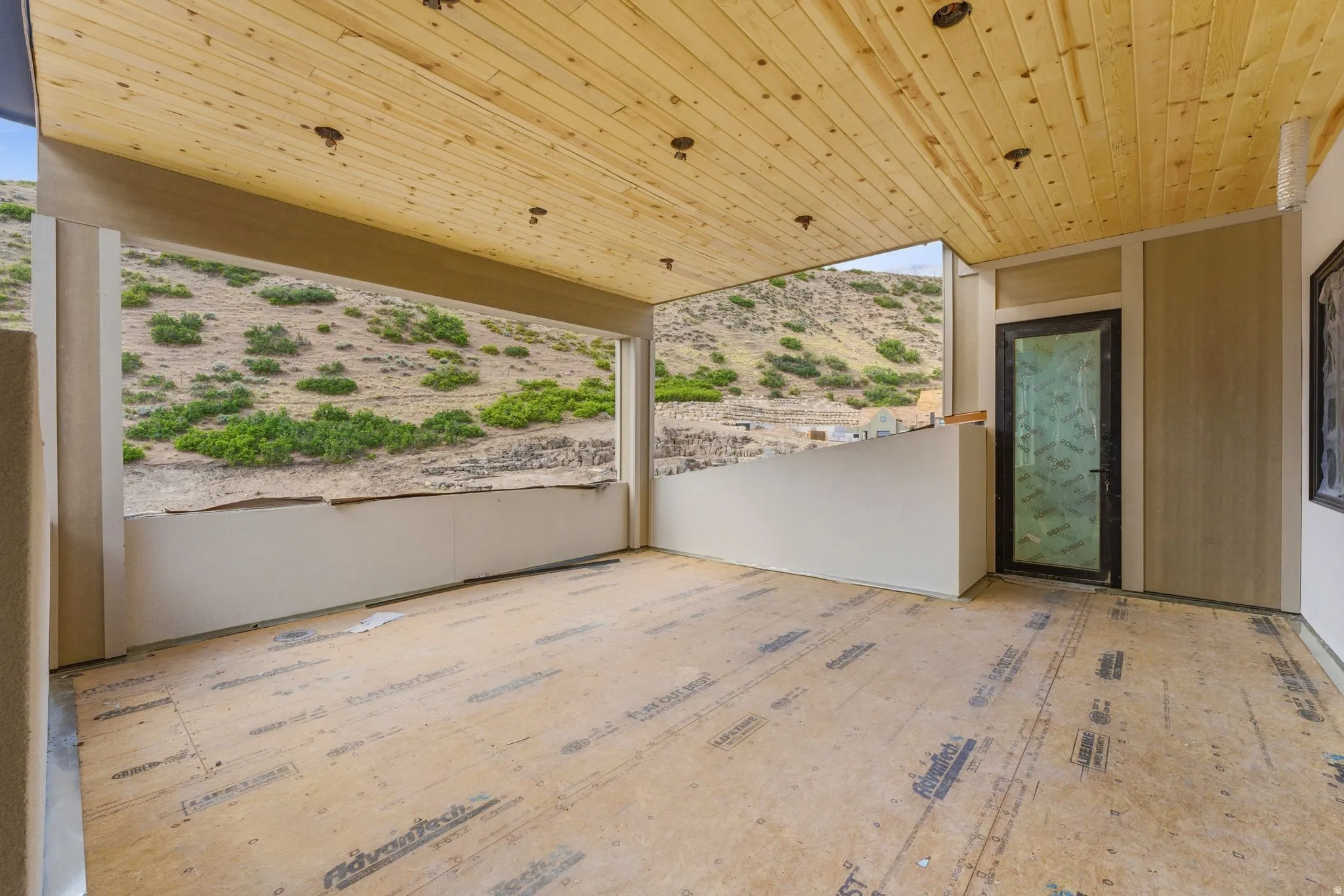 Expansive covered patio featuring a natural wood plank ceiling with recessed lighting