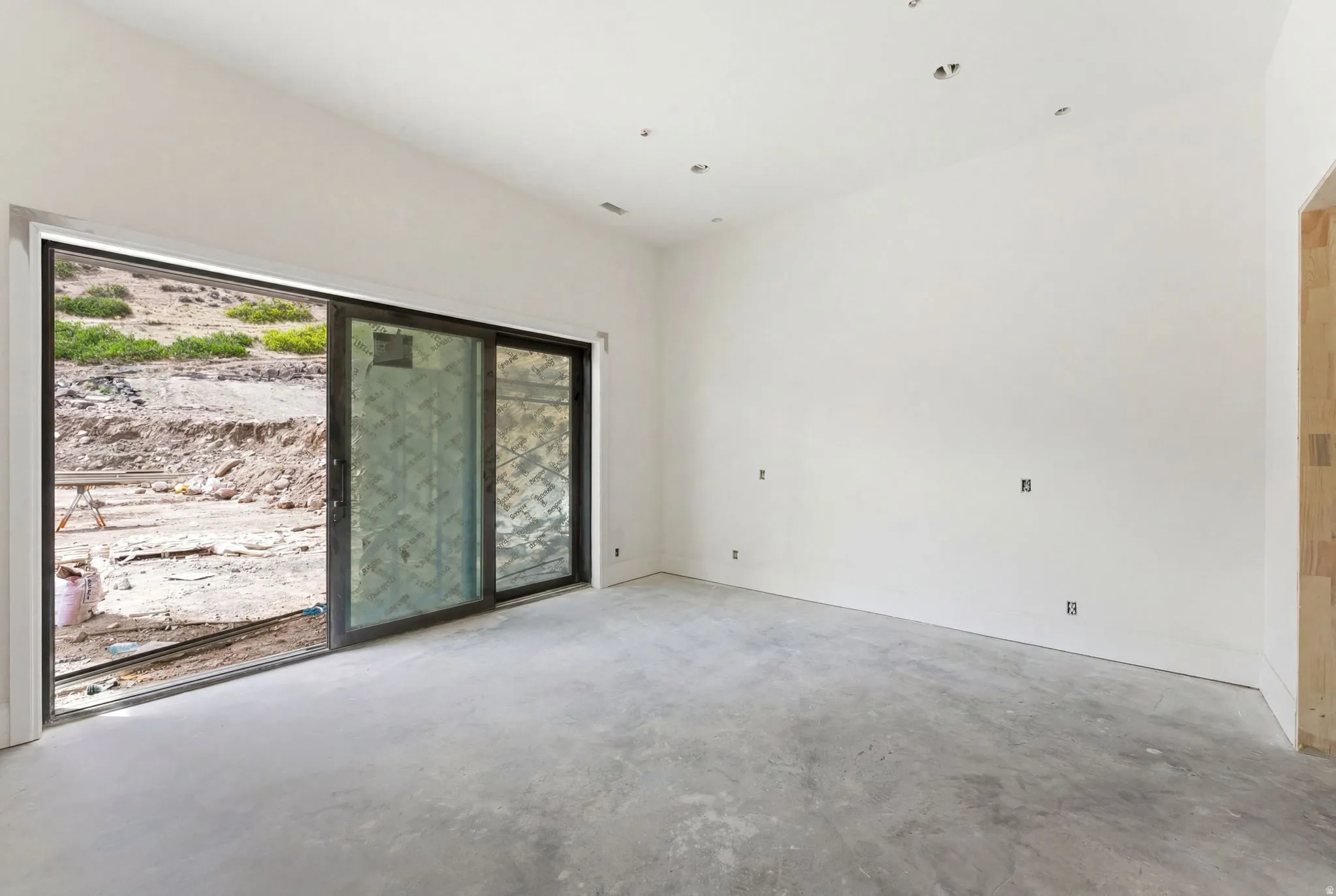 Spacious interior with concrete flooring and white walls