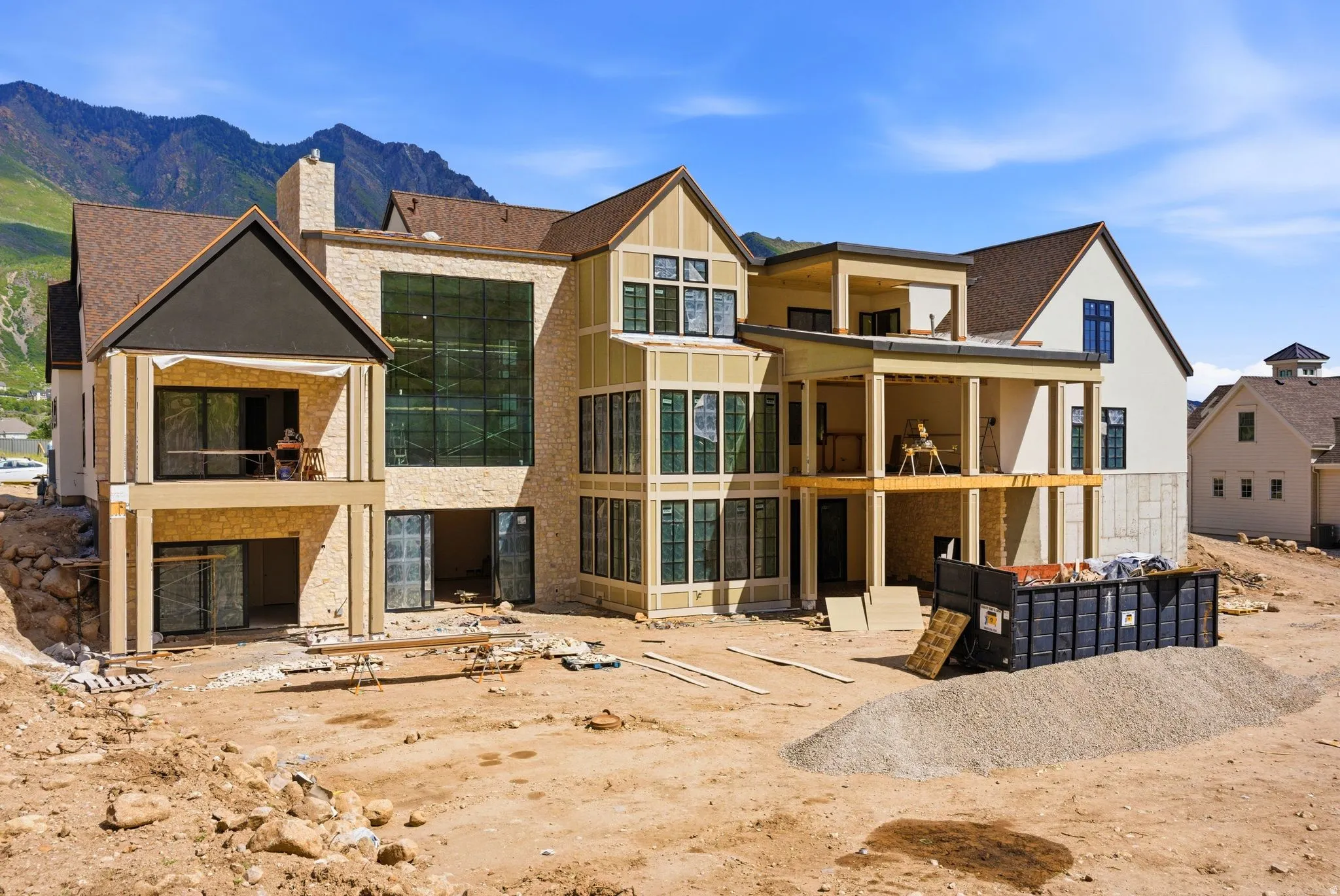Multi-level residence featuring stone and siding exterior, large windows, and multiple balconies
