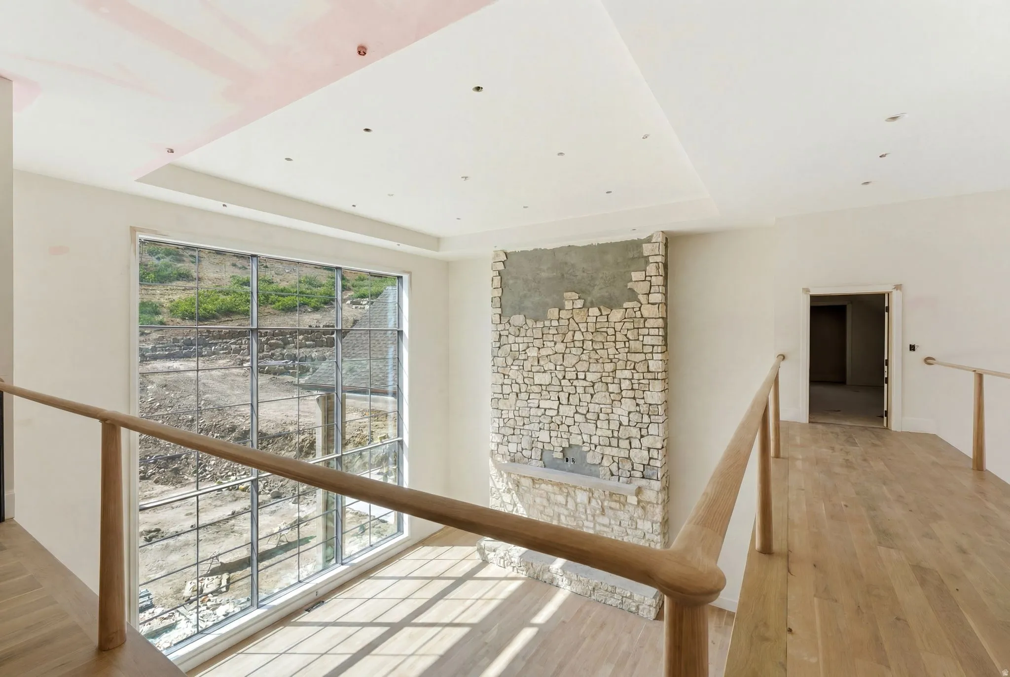 Spacious interior featuring a stone-clad fireplace and a prominent large window