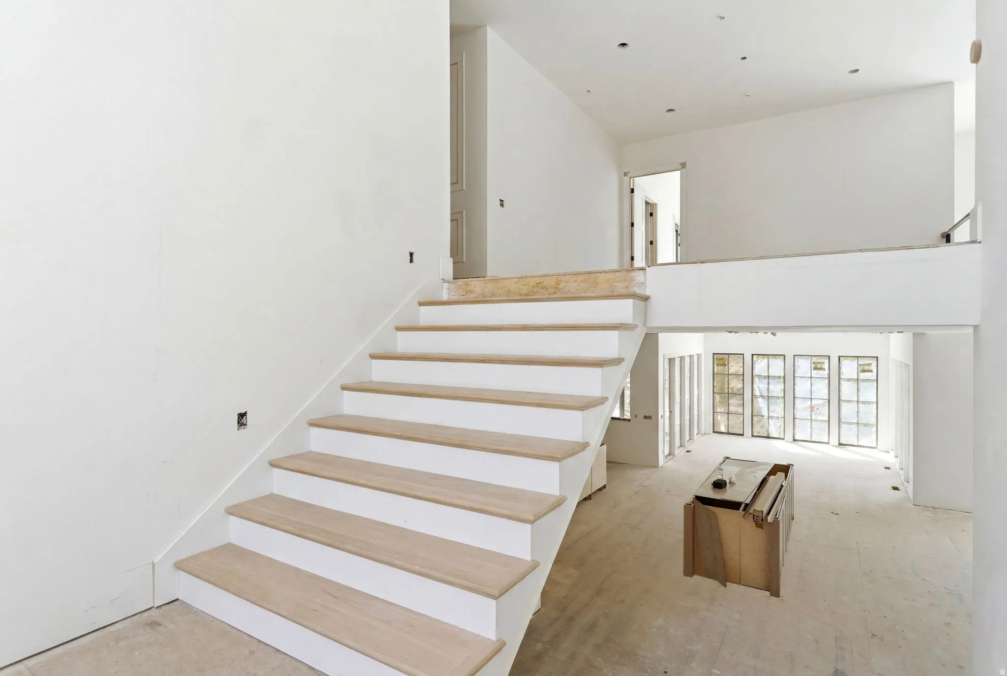 Grand staircase featuring light wood-finish treads and white risers
