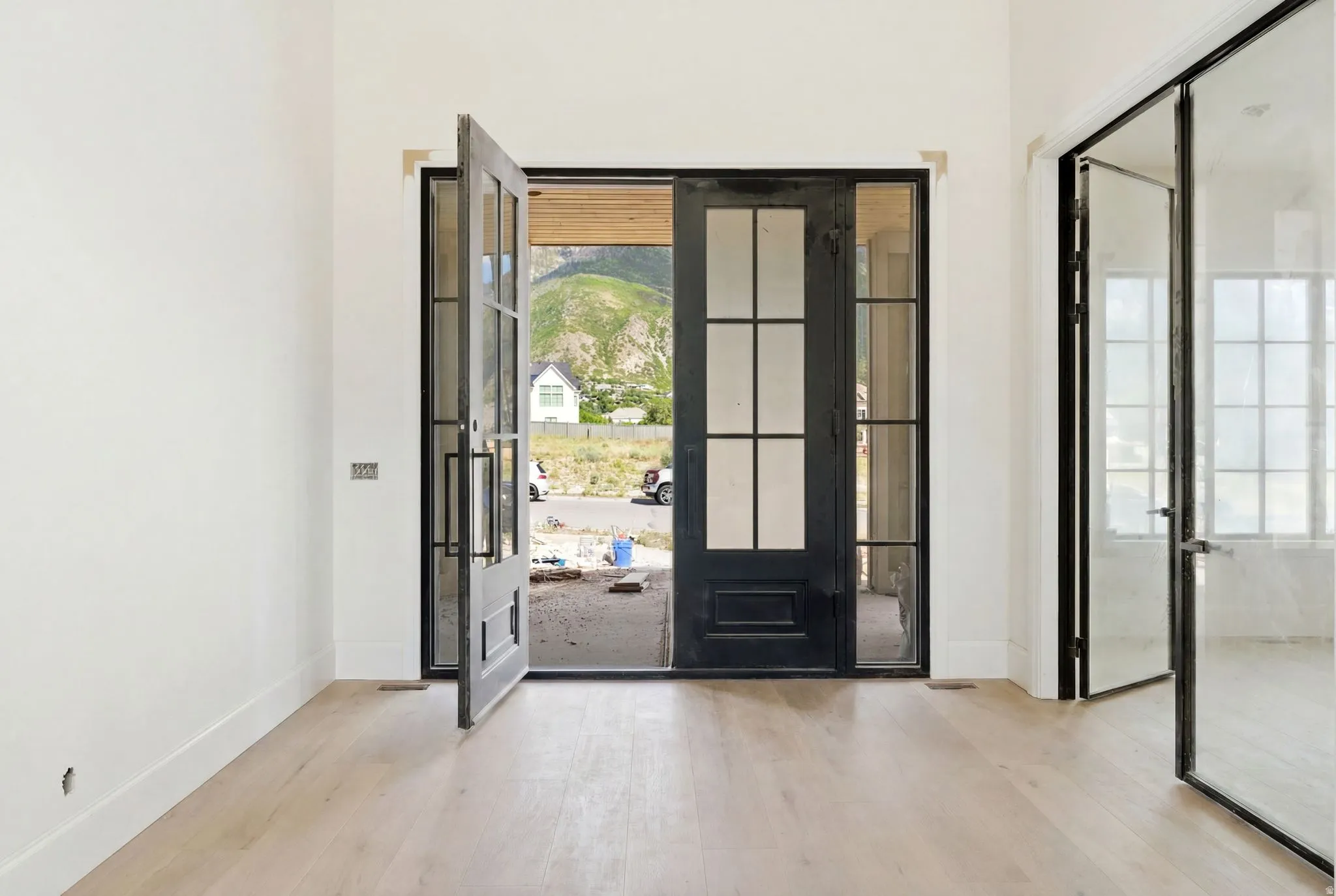 Light wood-finish flooring with white baseboards and walls