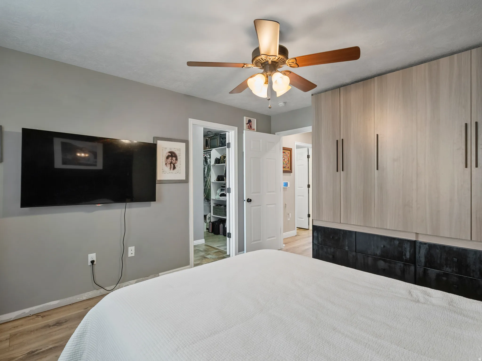 Built-in wardrobe system with light wood-finish cabinetry and dark lower drawers