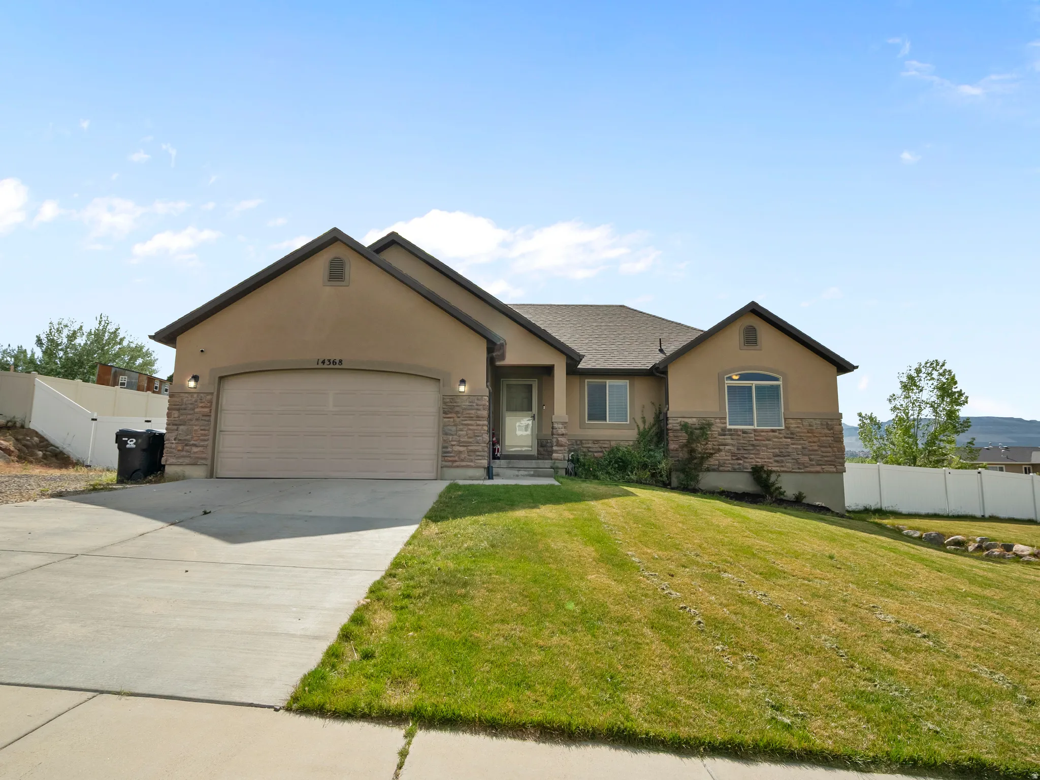 Ranch-style residence featuring a combination of stucco and stone veneer siding