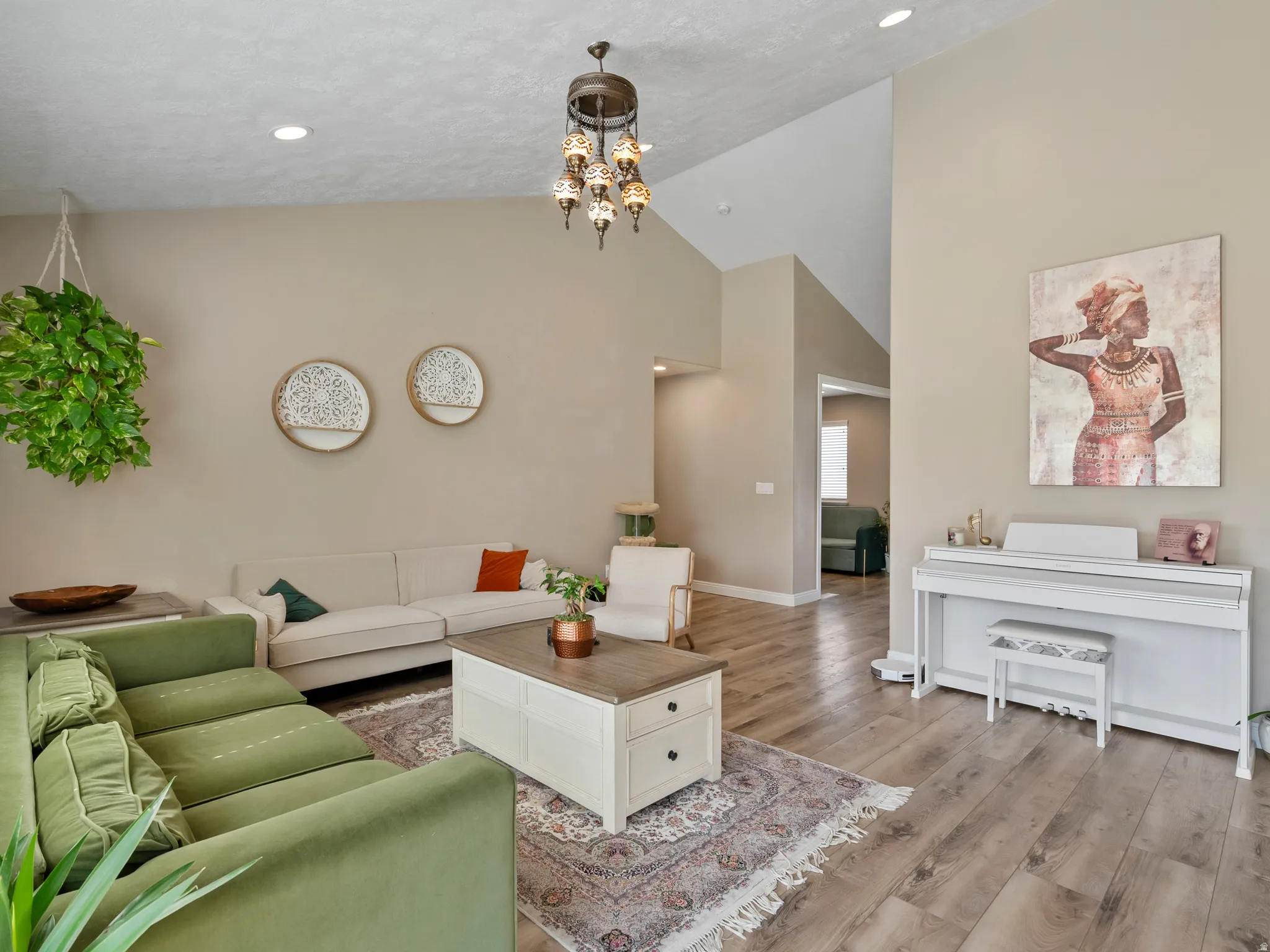 Spacious living area featuring vaulted ceilings, recessed lighting, and wood-finish flooring