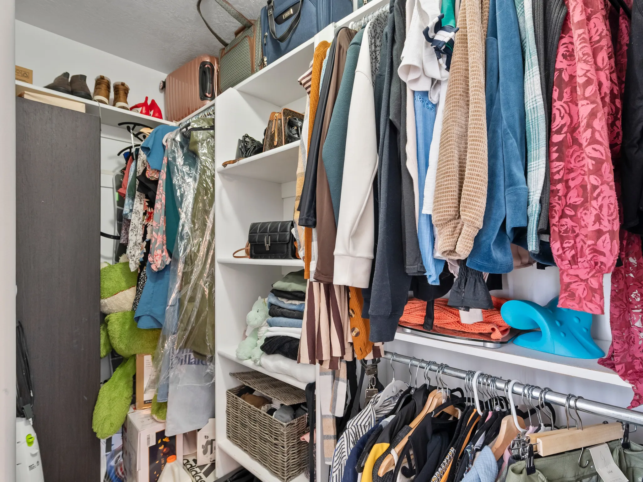 Custom closet system featuring multiple hanging rods, open shelving, and integrated storage