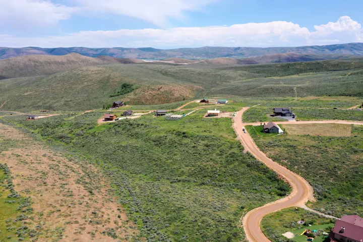 Rolling terrain featuring established homesites amidst natural vegetation and distant hills
