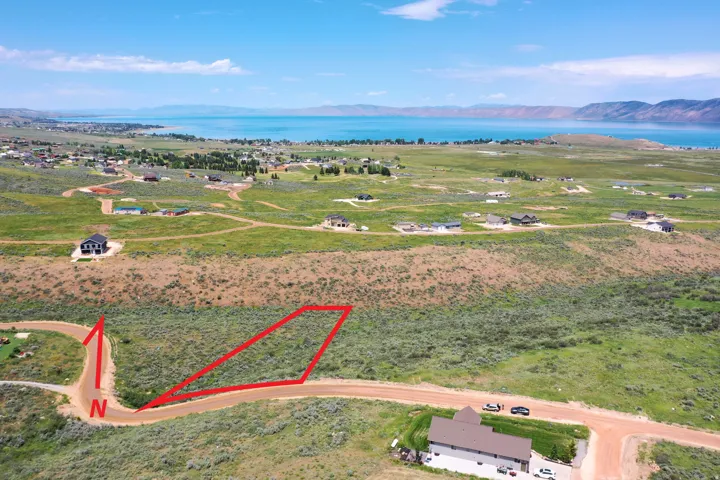 Expansive parcel with direct road frontage, surrounded by natural shrubland and distant residential structures