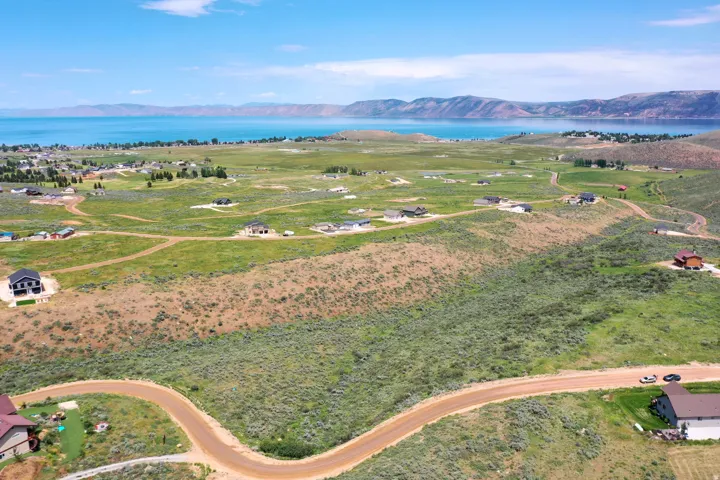 Expansive undeveloped land featuring natural grasses and shrubs, with a winding unpaved road