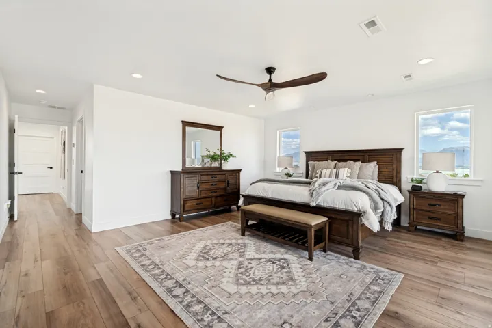 Spacious room featuring wood-finish flooring, recessed lighting, and a modern ceiling fan