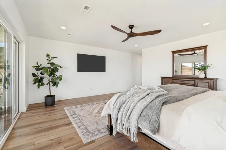 Spacious room featuring wood-finish flooring, recessed lighting, and a modern ceiling fan