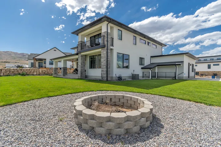 Manicured lawn with a gravel pathway leading to a block fire pit