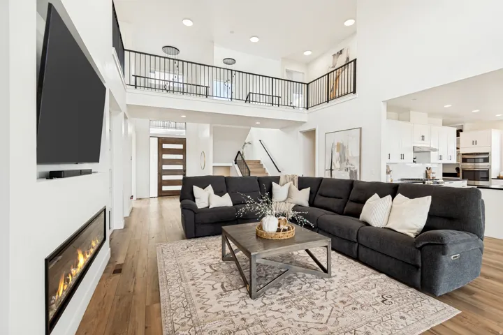 Open-concept living area with high ceilings and wood-finish flooring