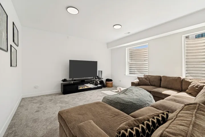 Carpeted living space with white walls and recessed lighting