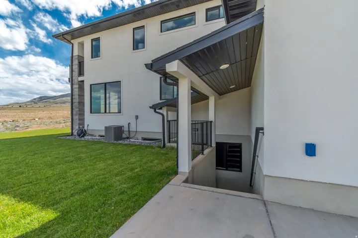Exterior stucco finish with dark-framed windows and an outdoor stairwell
